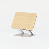 Adjustable laptop stand with light oak finish and coated steel base on white background.