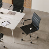 Black conference chairs with chrome frames arranged around a modern white meeting room table