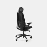 Rear-angle view of the Ergonomic Novo Chair in matte black, showcasing its adjustable headrest, contoured mesh backrest, and built-in lumbar support. Designed for ergonomic comfort and modern workspaces.