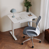 A top-down view of the Ergonomic Seashell Chair with a sculpted mesh back, curved armrests, and a polished metal base, positioned at a modern white desk in a cozy home office setting.