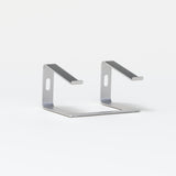Slim silver laptop stand with minimalist metal design on white background