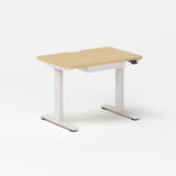 Small Standing Desk in light oak finish with white adjustable metal legs for compact ergonomic workspace