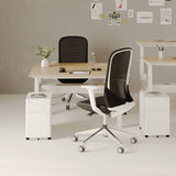 Urbanica two-person standing office desk setup with height-adjustable work surfaces, ergonomic mesh chairs, and modern white mobile storage pedestals in a creative team space