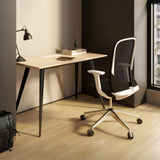 Urbanica SleekForm Ergonomic Office Desk with black steel legs and natural wood surface in a cozy, minimalist workspace by the window