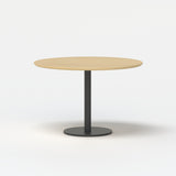 Urbanica round meeting table with light oak top and black pedestal base, minimalist studio shot