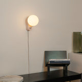 Alumina Lamp in Blossom finish mounted on a wall and used as a sconce in a modern hallway.