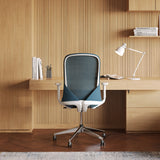 Rear view of the Urbanica Ergonomic Muse Chair in a modern wood-accented home office, featuring breathable mesh back, contoured support, and sleek adjustable armrests for all-day comfort.