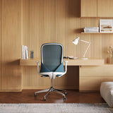 Urbanica Ergonomic Muse Chair styled in a modern wood-accented home office, emphasizing its curved mesh backrest, sculpted silhouette, and ergonomic functionality.